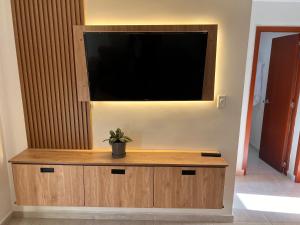 a flat screen tv on a wall with a potted plant at Refugio Tenerife San Gil in San Gil