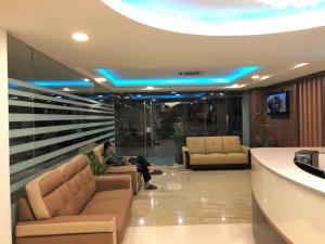 a man sitting on a couch in a lobby at ECO Hotel at Bukit Bintang in Kuala Lumpur