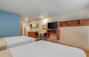 a hotel room with two beds and a desk with a tv at Extended Stay America Select Suites - Atlanta - Chamblee in Atlanta