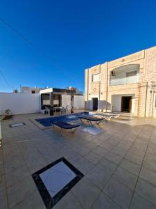 a patio with two benches and a building at Omaima villa in Taguermess