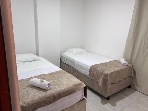 two beds in a small room with towels on them at Refugio Tenerife San Gil in San Gil