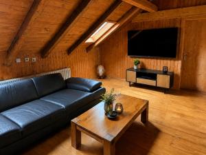 a living room with a black couch and a coffee table at Alpine Serviced Apartment with Mountain Views in Cazis