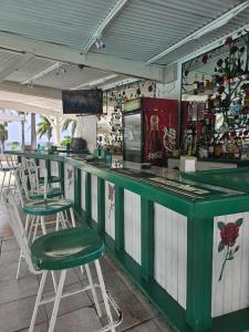 a green and white bar with two chairs and drinks at A World Away in Montego Bay