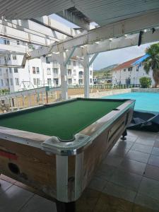 a pool table on a patio next to a swimming pool at A World Away in Montego Bay