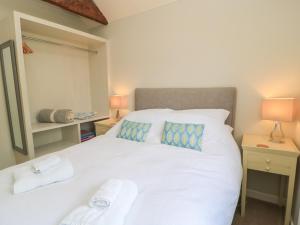 a bedroom with a white bed with two pillows at The Cider Press, Motcombe, Shaftesbury in Motcombe