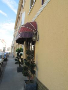 een gebouw met een paraplu aan de kant van een straat bij Hotel Victor Hugo in Dijon