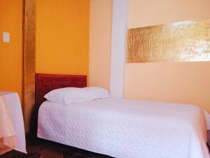 a bedroom with a white bed and orange walls at 1 BR Room 1 floor Cusco in Cusco