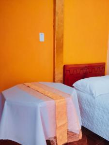 a room with two beds and a table with a cloth at 1 BR Room 1 floor Cusco in Cusco +3 photos