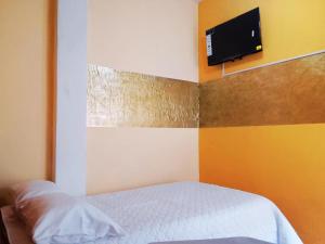 a bedroom with a bed and a tv on the wall at 1 BR Room 1 floor Cusco in Cusco