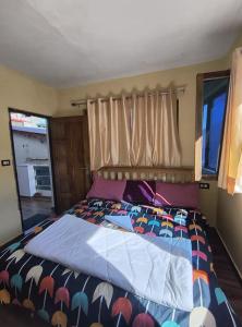 a bedroom with a bed with a colorful comforter at Hotel New Aroma inn in Tājganj
