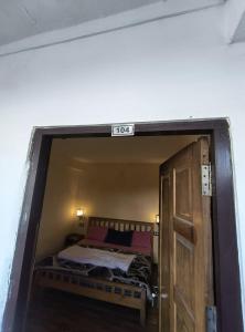 a small room with a bed and a door at Hotel New Aroma inn in Tājganj +2 photos