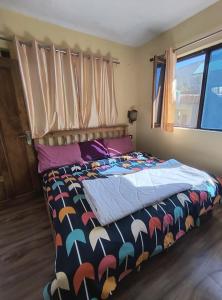 a bedroom with a bed with a colorful comforter at Hotel New Aroma inn in Tājganj