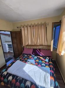 a bedroom with a bed with a colorful comforter at Hotel New Aroma inn in Tājganj