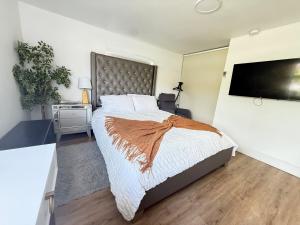 a bedroom with a large bed and a flat screen tv at Private Suite with Laundry in Sunset