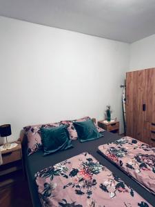 a bedroom with two beds with green pillows at Kuća za odmor MEDUNIĆ in Gospić