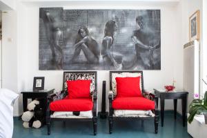 twee rode stoelen in een kamer met een schilderij aan de muur bij Modern, fully equipped apt with private balcony - CT1 in Athene