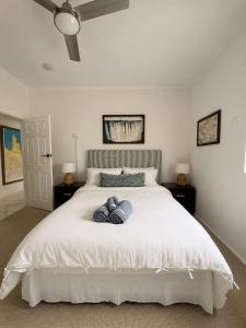 a bedroom with a white bed with two pillows on it at 'The Station House' Mount Isa in Mount Isa