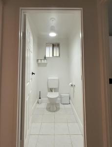a bathroom with a toilet and a white tile floor at 'The Station House' Mount Isa in Mount Isa