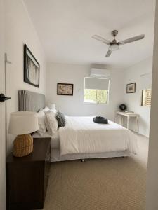 a white bedroom with a bed and a ceiling fan at 'The Station House' Mount Isa in Mount Isa +12 photos