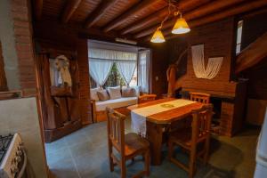 a dining room with a table and chairs and a bed at Cabañas Murmullo de Agua in Mar de las Pampas