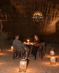 a man and woman sitting at a table with a candle at RUM LlNA lUXRY CAMP in Wadi Rum