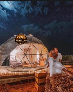 a bride and groom standing in front of a yurt at RUM LlNA lUXRY CAMP in Wadi Rum
