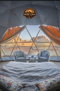 a room with two chairs and a bed in a tent at RUM LlNA lUXRY CAMP in Wadi Rum