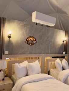 a bedroom with two beds and a sign on the wall at RUM LlNA lUXRY CAMP in Wadi Rum
