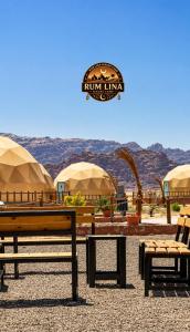 a group of benches and umbrellas with mountains in the background at RUM LlNA lUXRY CAMP in Wadi Rum +59 photos