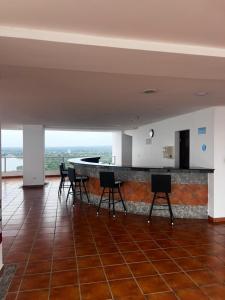 a room with chairs and a bar in a building at Beach apartment on the seashore in Las Lajas