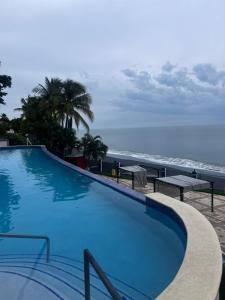 a swimming pool with a view of the ocean at Beach apartment on the seashore in Las Lajas