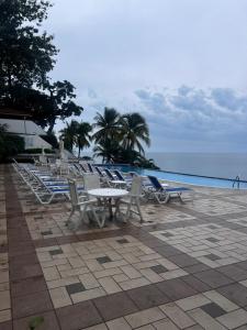 a group of lounge chairs and tables on the beach at Beach apartment on the seashore in Las Lajas
