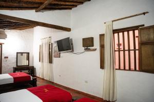 a bedroom with a bed and a tv on the wall at Hotel Boutique Macaregua Girón in Girón
