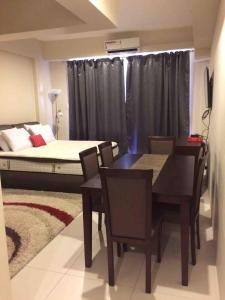a dining room with a bed and a table and chairs at 1BR Condo Unit in Pico De Loro in Nasugbu