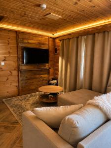 a living room with a couch and a table at Chalé Recanto 39 Luxury Mountain Retreat in Penhas da Saúde