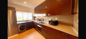 a kitchen with brown cabinets and a sink and a microwave at Orange Place - Benson Close in Lagos
