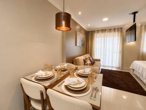 a kitchen and living room with a table and chairs at Luxury Studio - Próx Aeroporto GRU - Com Ar Condicionado in Guarulhos +18 photos