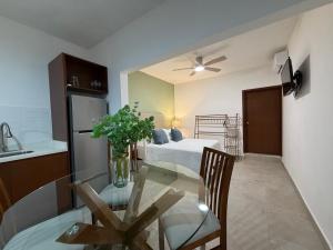 a kitchen with a glass table and a bed at Casa DOS21 Boutique Apartments Playa Sur in Mazatlán