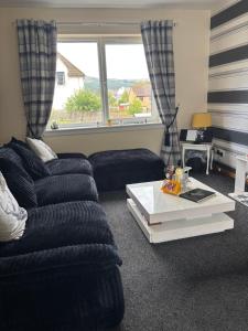 a living room with a couch and a table at Cameron apartment Loch Ness in Fort Augustus