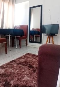a room with chairs and a mirror and a rug at Apto completo centro in Rio Grande +3 photos