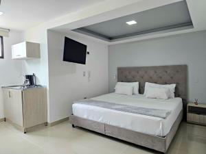 a bedroom with a large bed and a flat screen tv at 110 Loft in Cali