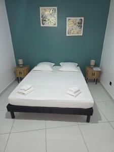 a large bed in a room with two tables at Bas de villa in Grand-Bourg