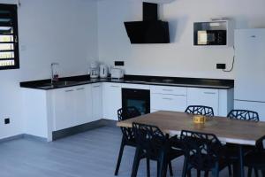 a kitchen with a table and chairs and a microwave at Bas de villa in Grand-Bourg +5 photos