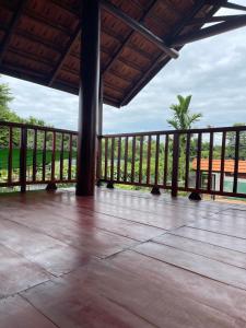 a porch with a fence and a palm tree at Ako BM homestay in Buon Ma Thuot
