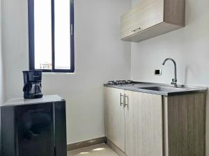 a kitchen with a sink and a coffee maker in it at 110 Loft in Cali