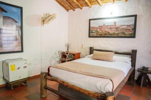 a bedroom with a bed and a picture on the wall at Hotel Boutique Macaregua Girón in Girón