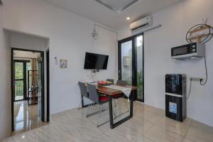 a dining room with a table and a tv at Villa Astella in Nusa Penida