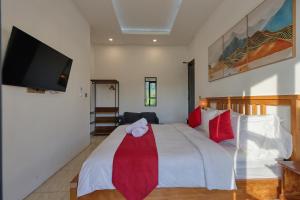 a bedroom with a white bed and a flat screen tv at Villa Astella in Nusa Penida +79 photos