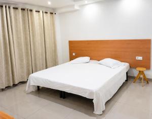a bedroom with a large bed and a wooden headboard at Mags GuestHouse in Praia