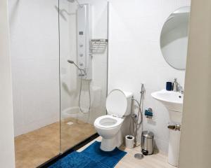 a bathroom with a shower and a toilet and a sink at Mags GuestHouse in Praia